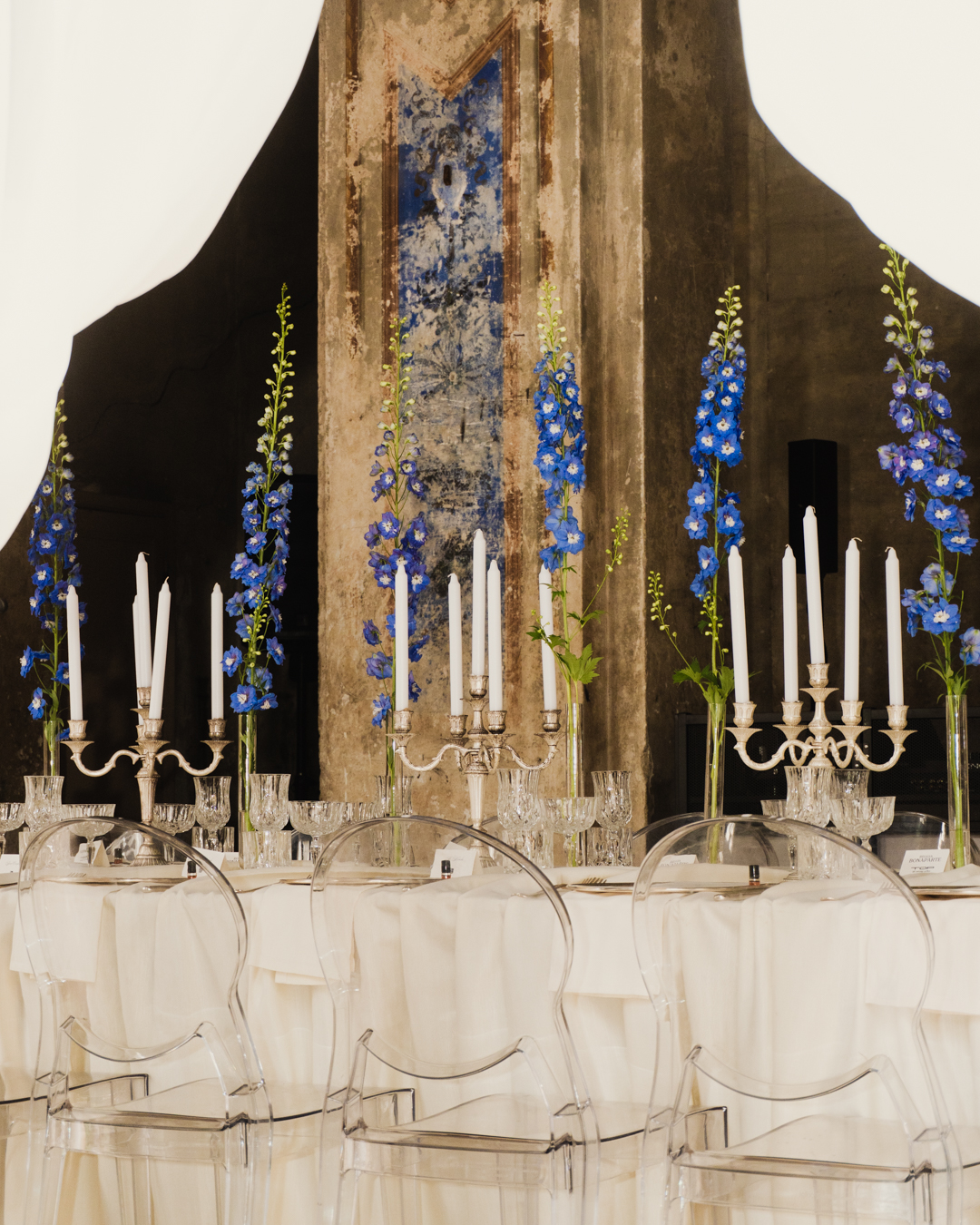 Convitio elegant banquet table with blue delphiniums and silver candelabras
