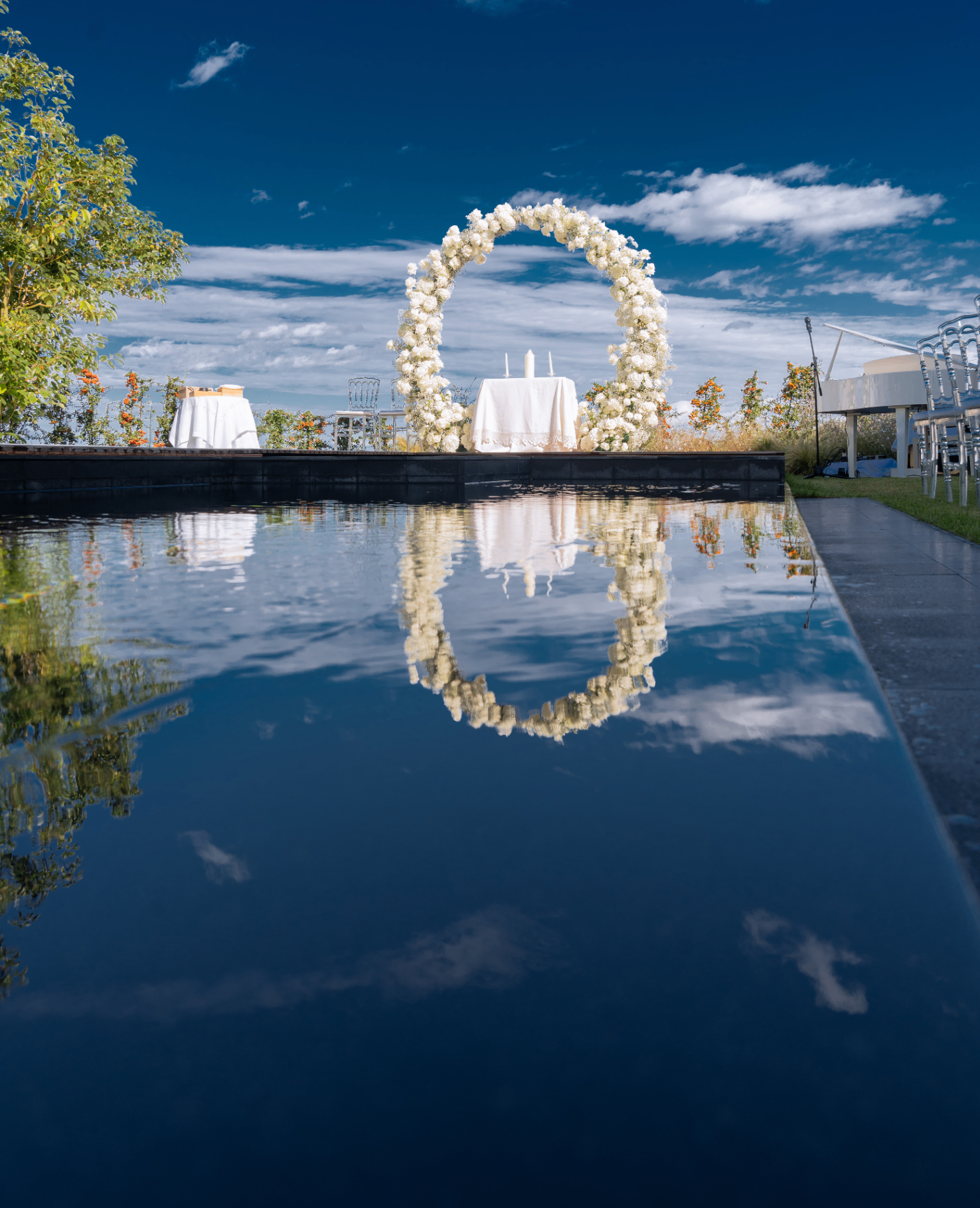 Convitio poolside ceremony with white floral arch